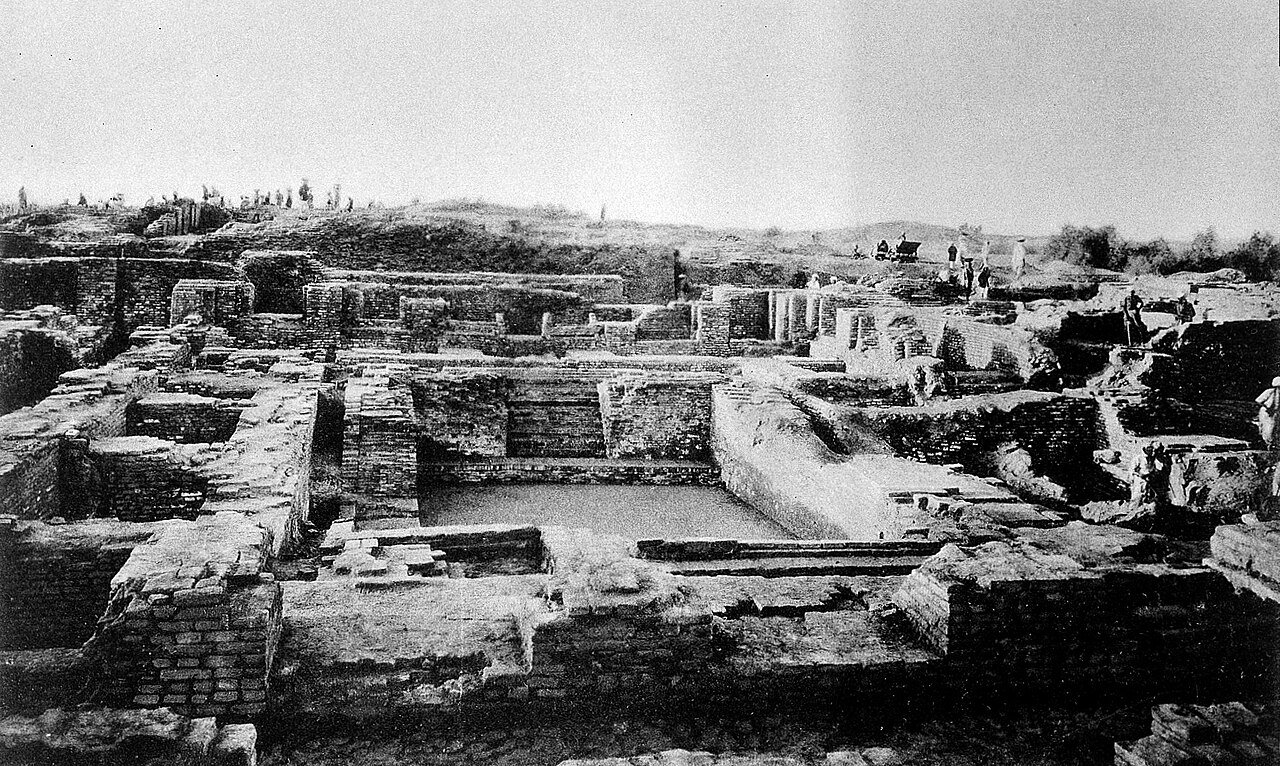 An archival photograph shows excavation around the Great Bath at Mohenjo-daro.